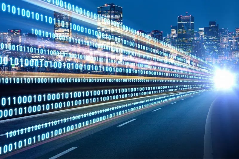A digital highway of binary code streams through a vibrant cityscape at night, with bright lights and skyscrapers, symbolizing fast data transfer.